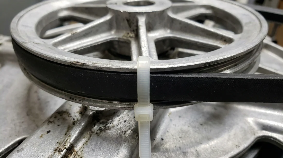 Utilisation d'un collier de serrage Rislan pour maintenir la courroie sur la poulie du tambour